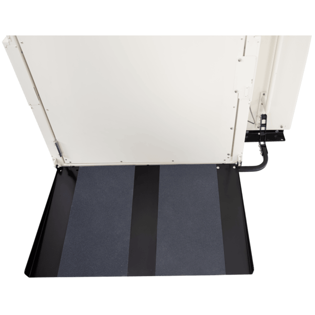 Wheelchair lift platform, black and gray with a white door, outdoors.