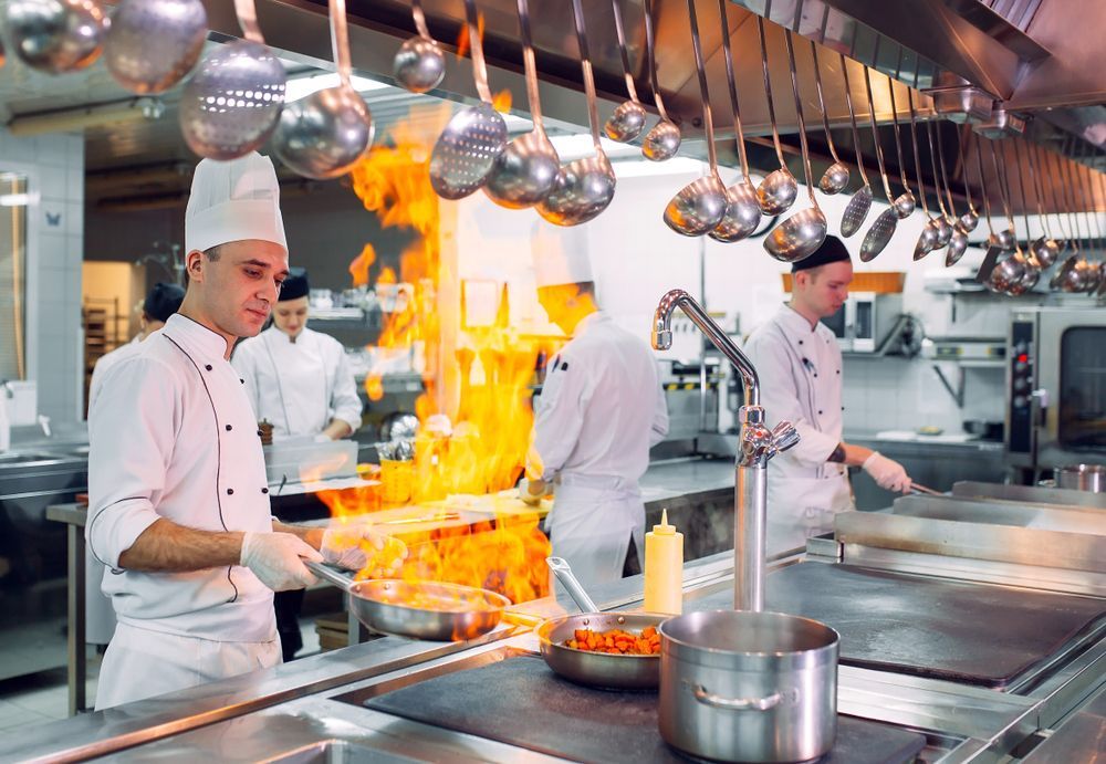 Chefs Cooking in a Commercial Kitchen With Flames — Chefs2Go in Ayr, QLD
