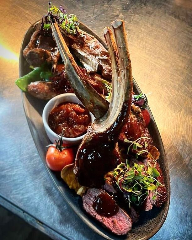 a Platter of Cooked Meats, Including a Large Lamb Chop, With Sauce and Garnishes — Chefs2Go in Woodwark, QLD