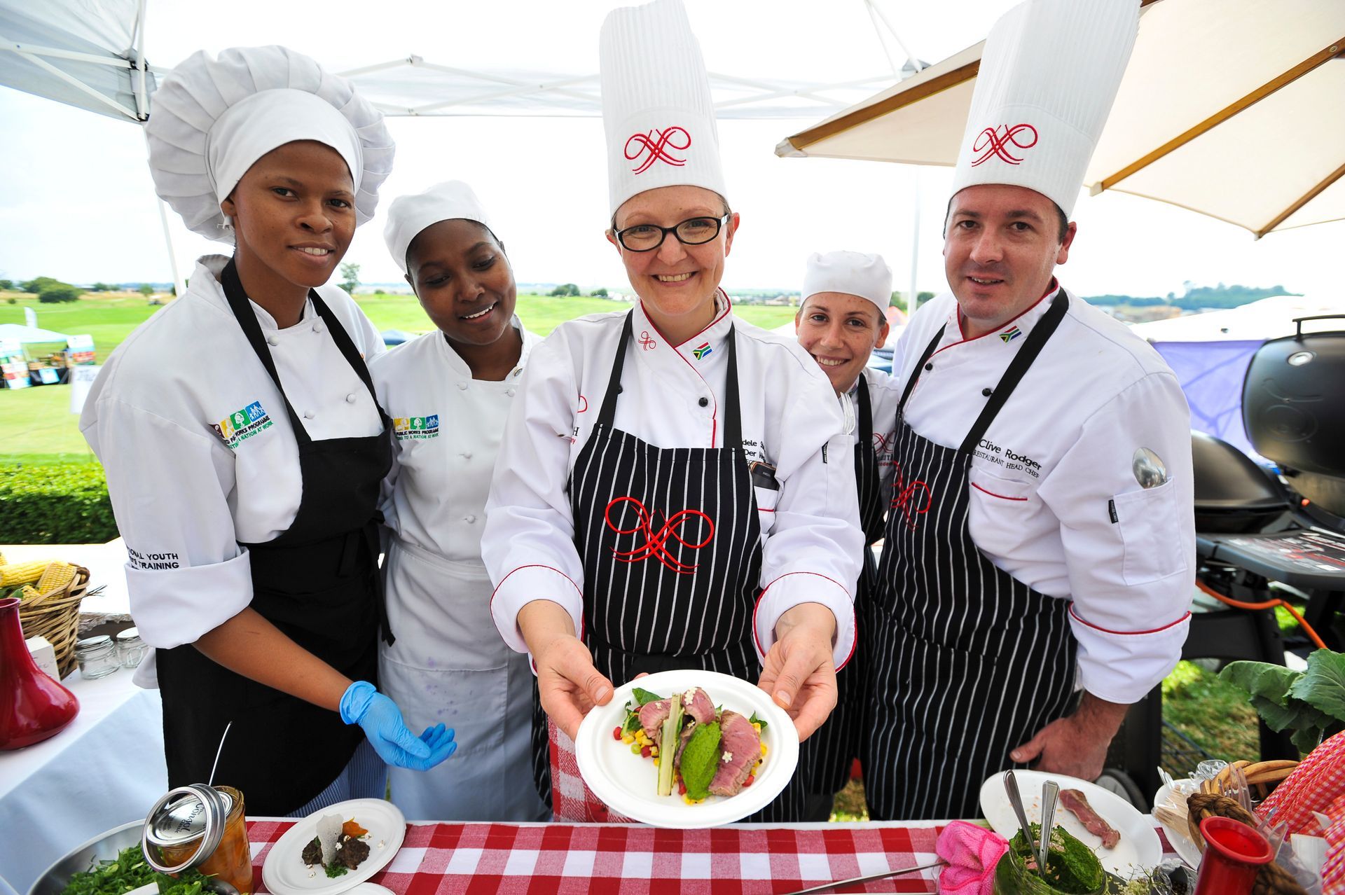 Chefs Presenting Food Outdoors, on Red Checkered Tablecloth — Chefs2Go in Woodwark, QLD