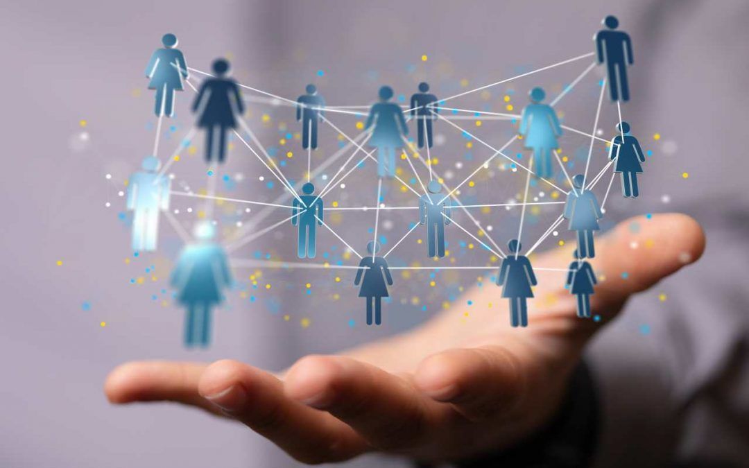 A person is holding a network of people in their hand.