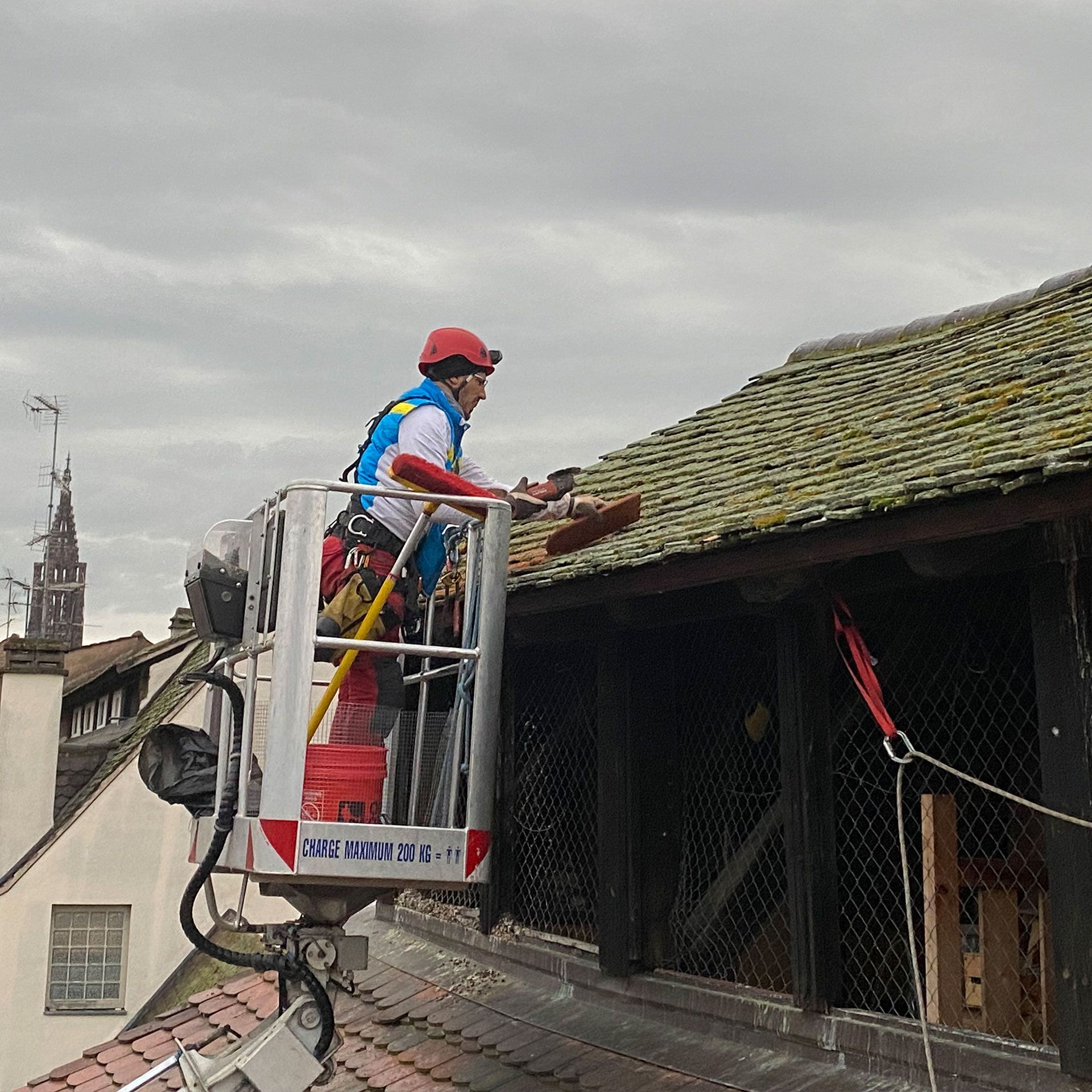 Un homme travaille sur le toit d'un immeuble dans un seau