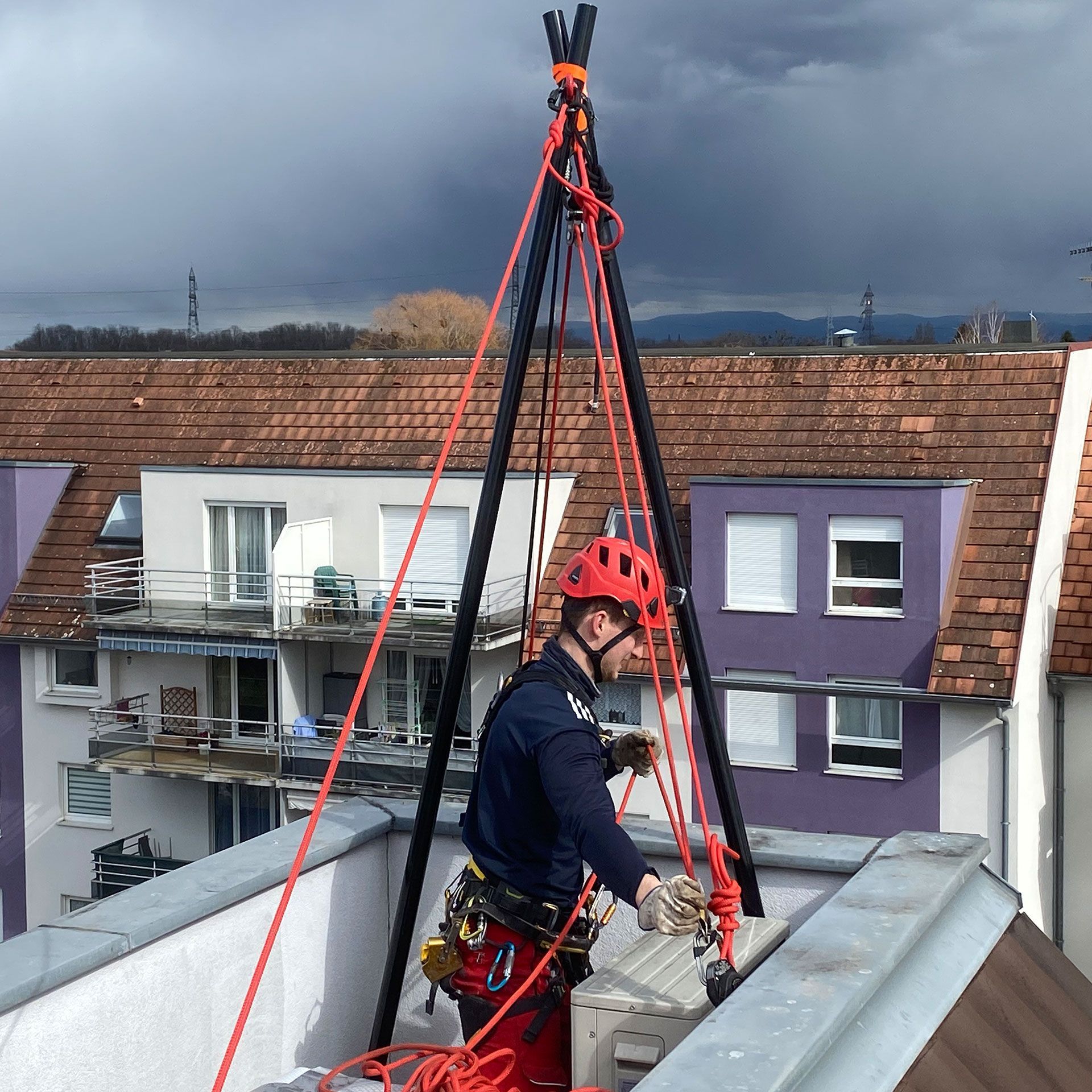Un homme portant un casque rouge travaille sur un toit