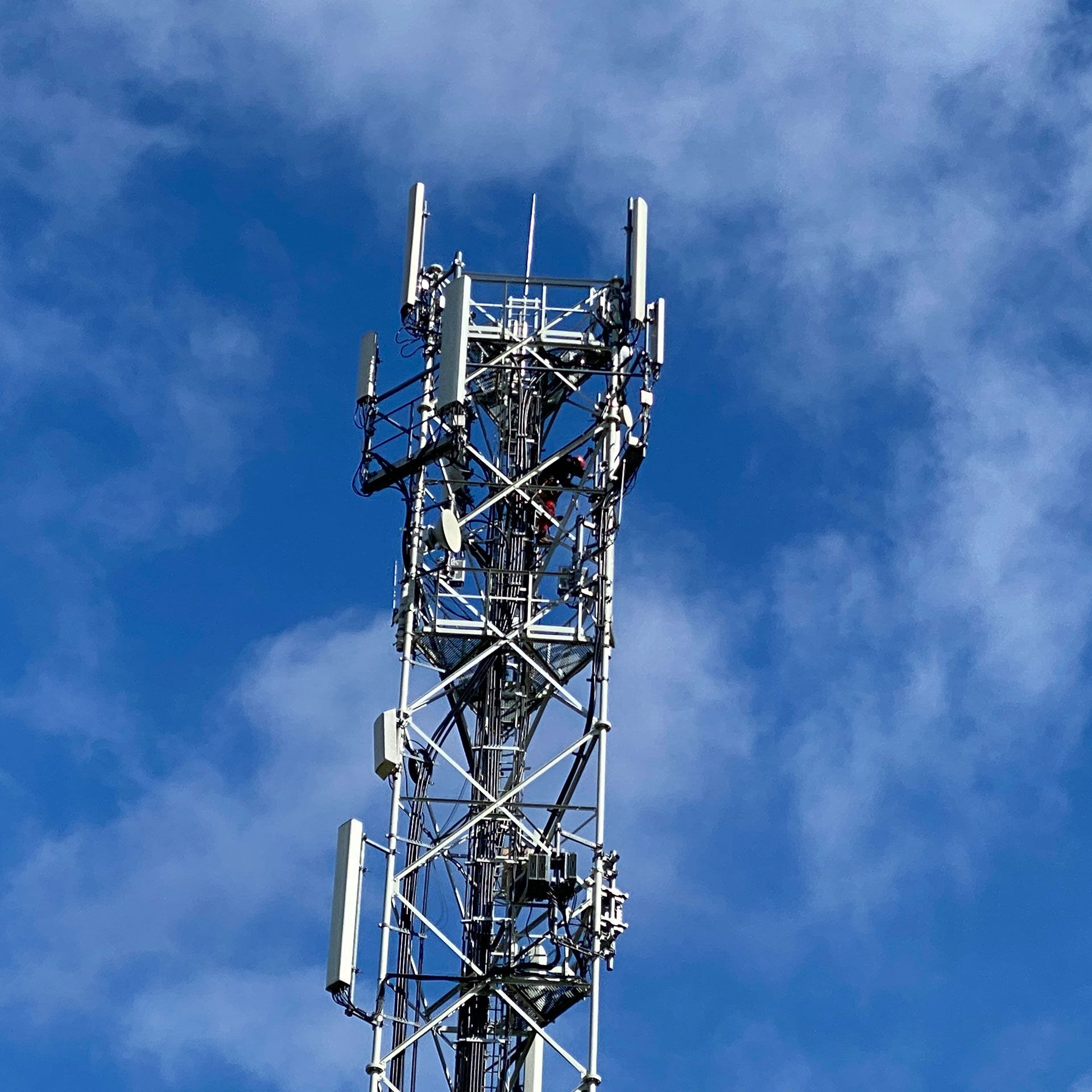 Une très haute tour d'antenne avec un ciel bleu en arrière-plan