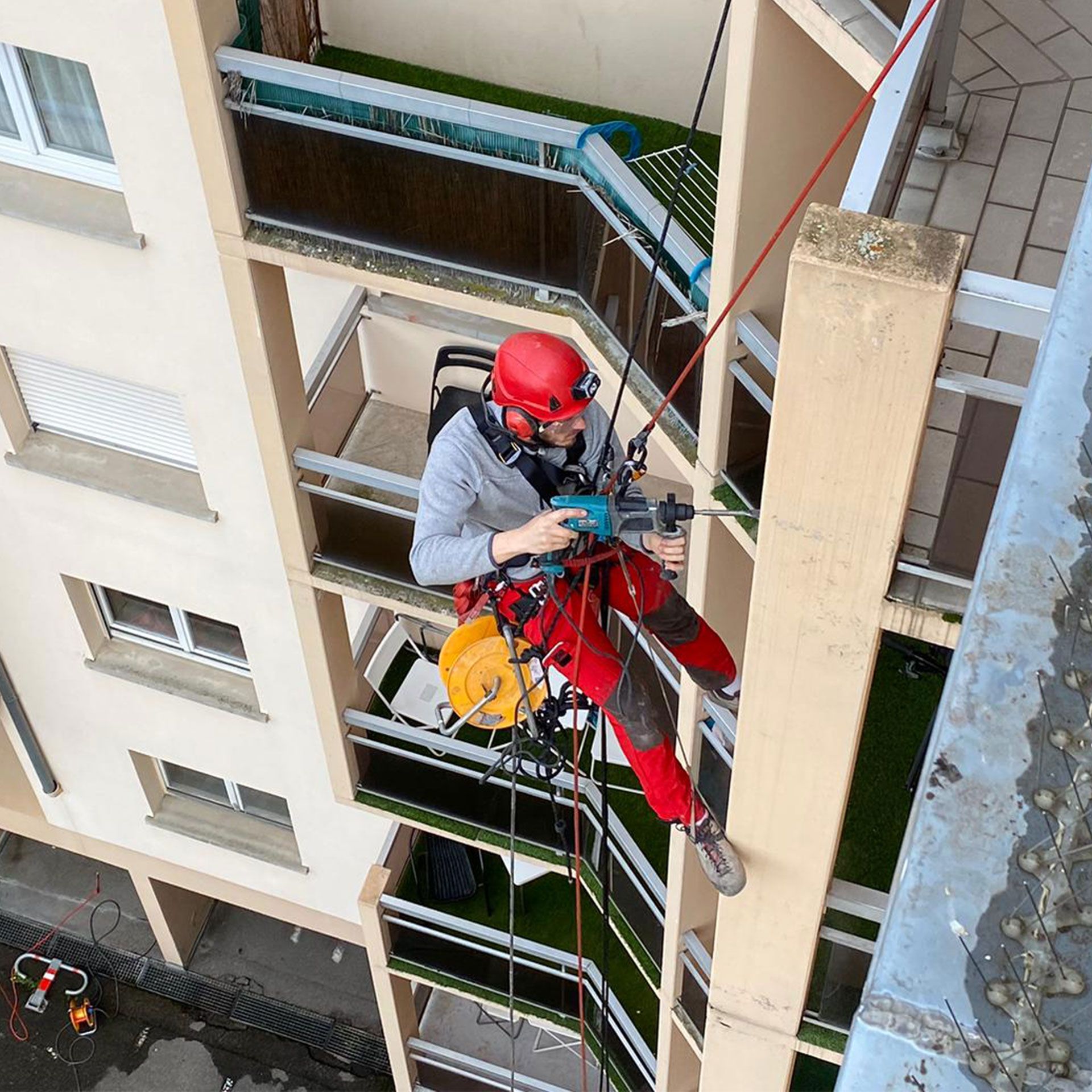Un homme portant un casque rouge escalade un bâtiment