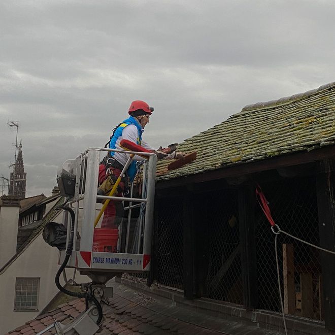 Un homme travaille sur le toit d'un immeuble dans un seau