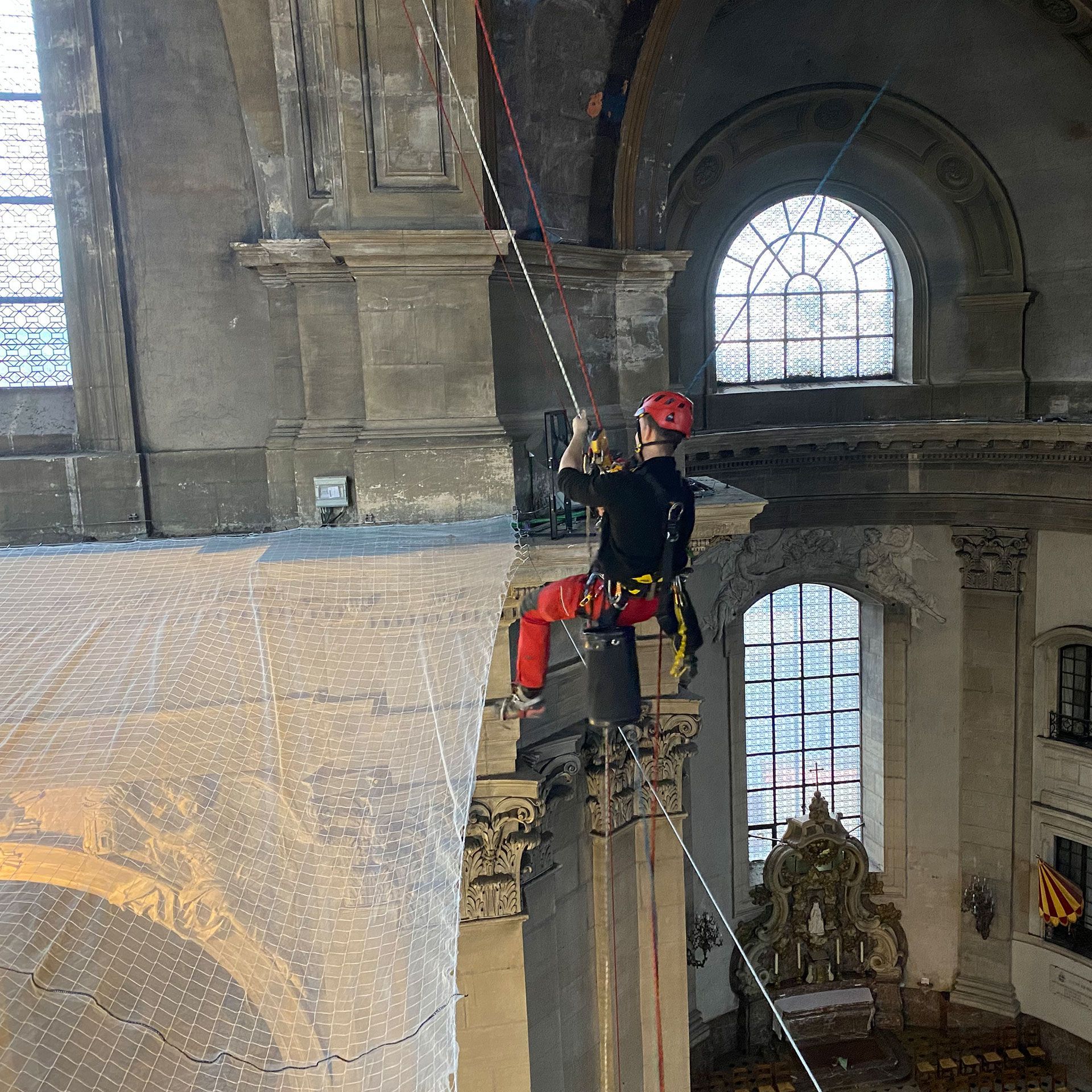 Un homme grimpe sur un très grand bâtiment
