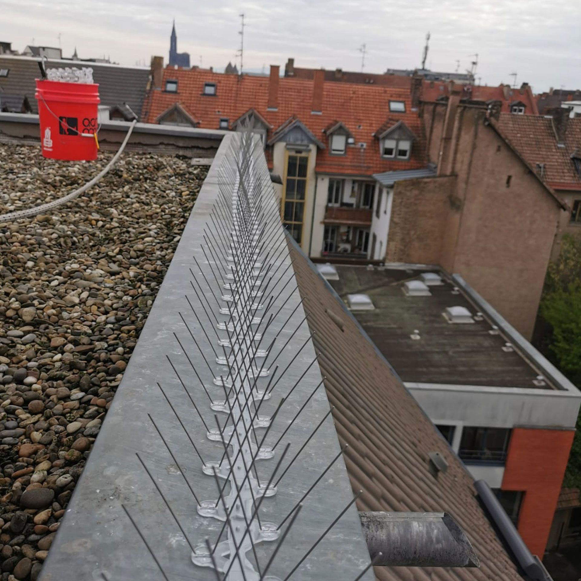 Un seau rouge sur le toit d'un bâtiment avec écrit « sg » dessus