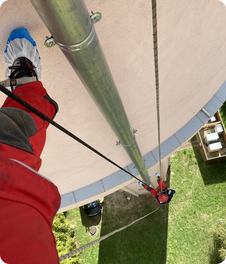 Une personne portant une veste rouge grimpe à un poteau