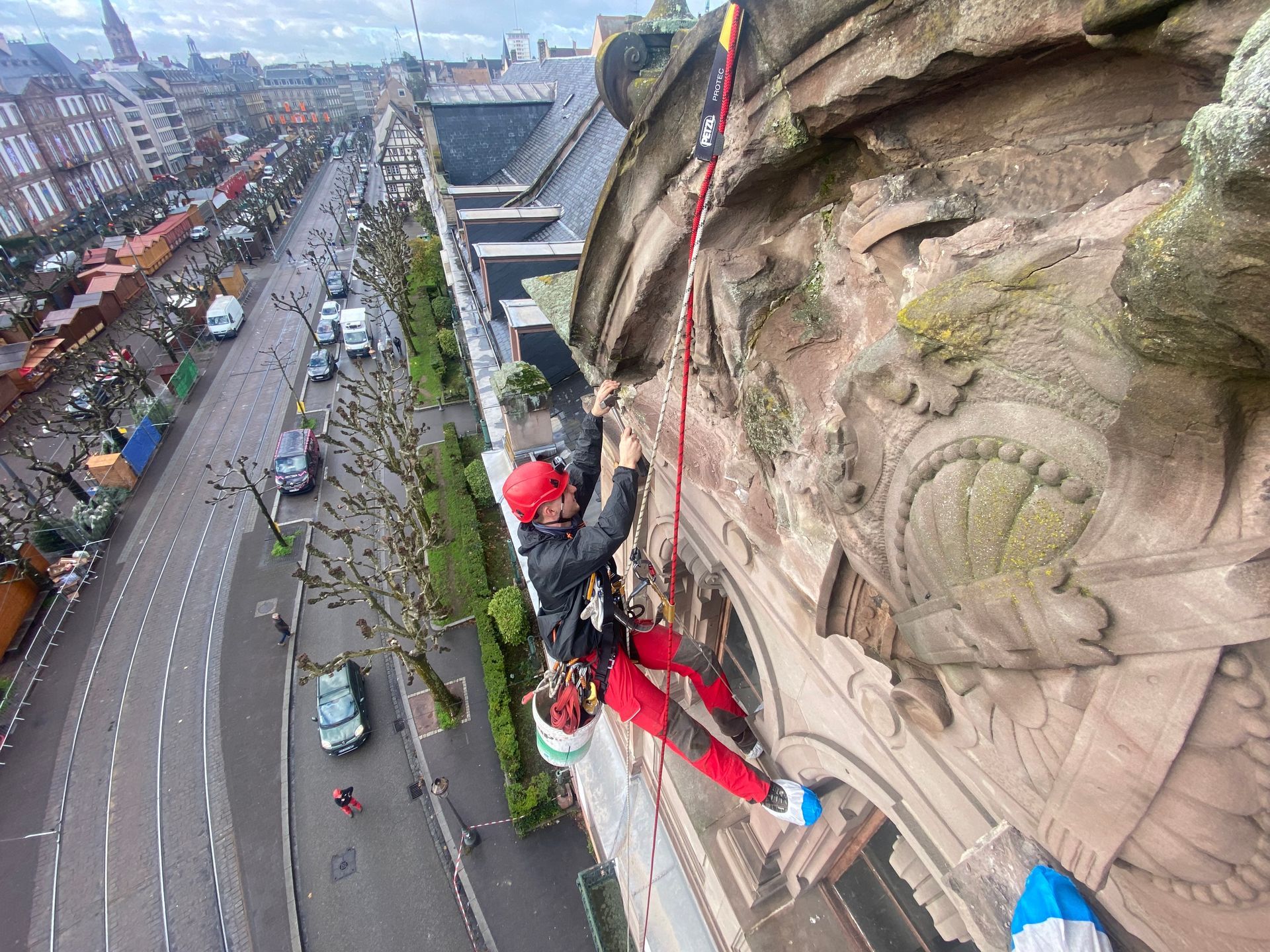 Un homme grimpe sur le côté d'un bâtiment.