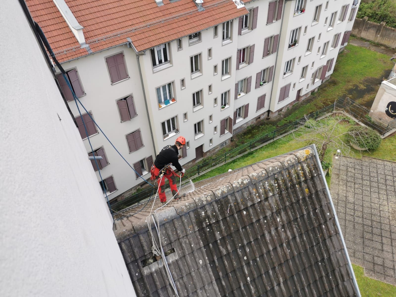 Un homme travaille sur le toit d'un immeuble.