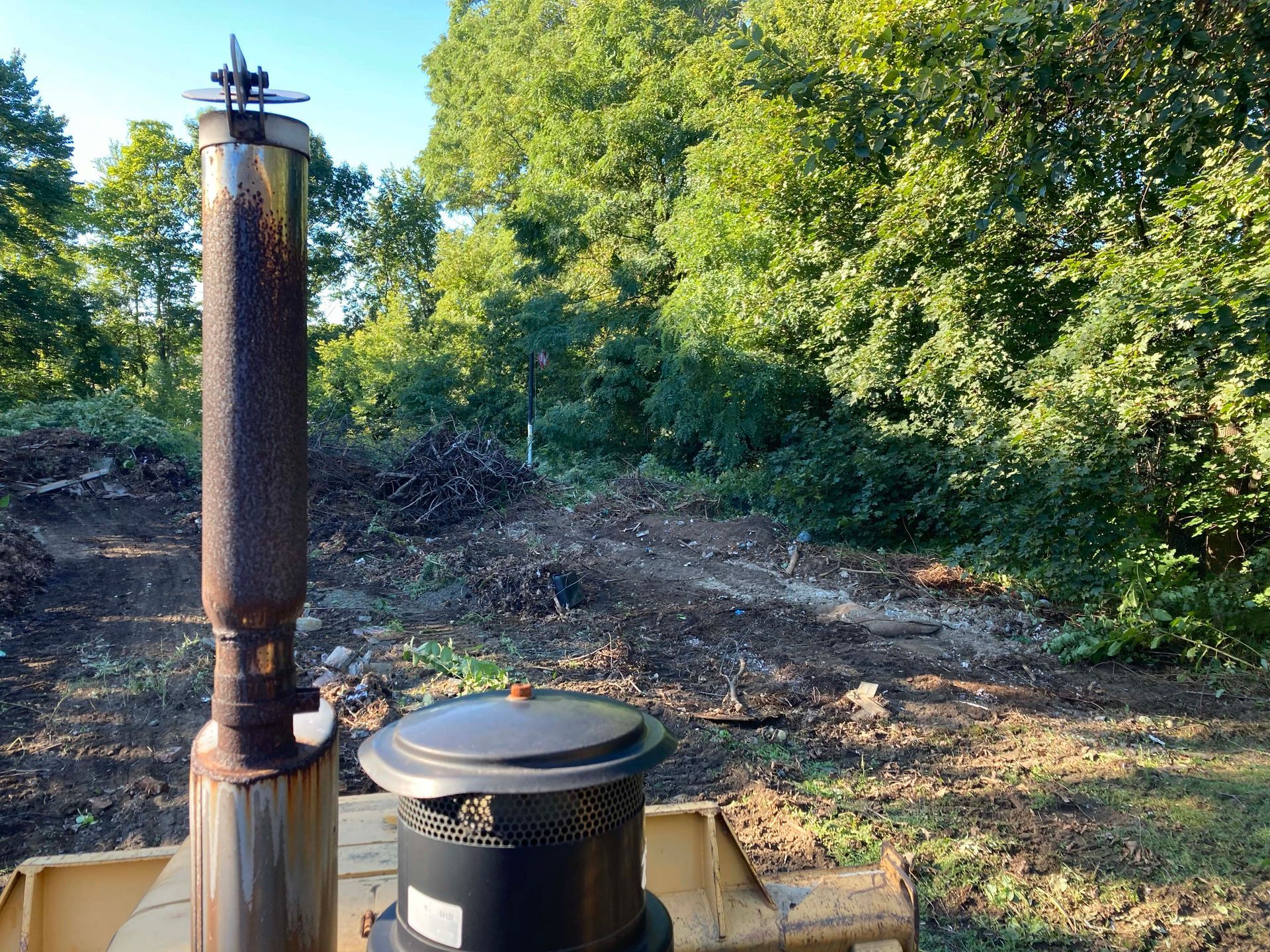 A large chimney is sitting in the middle of a forest.