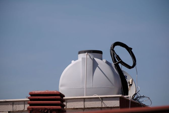 Black dome-shaped utility chamber with blue pipes in a dirt excavation site