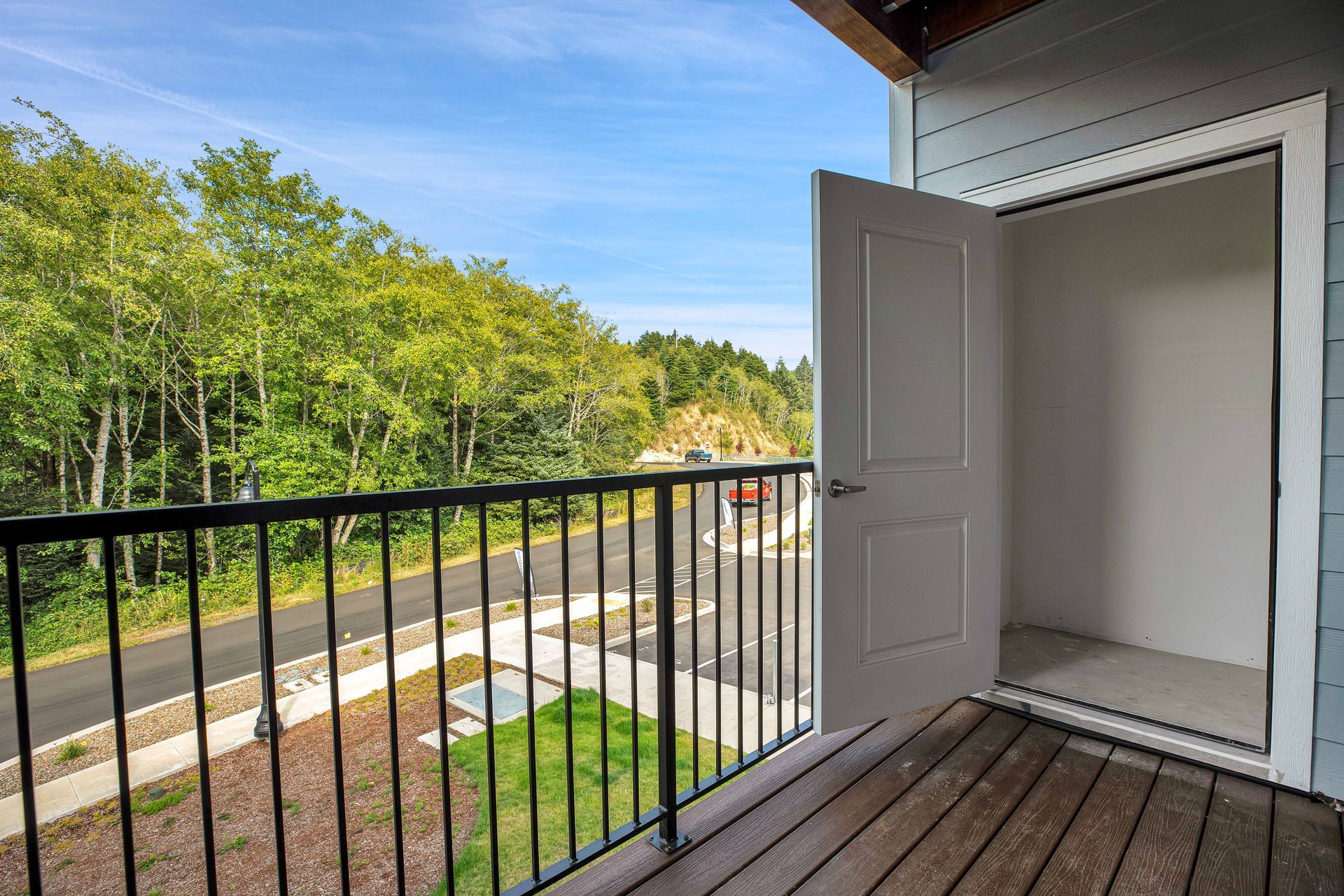There is a balcony with a railing and a door open.