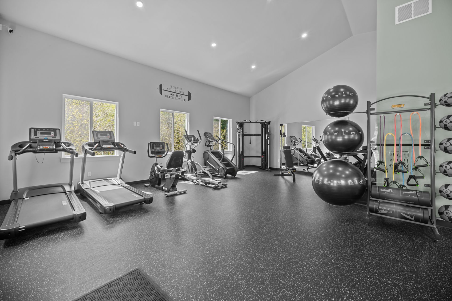 A gym with treadmills , exercise bikes , and a large exercise ball.