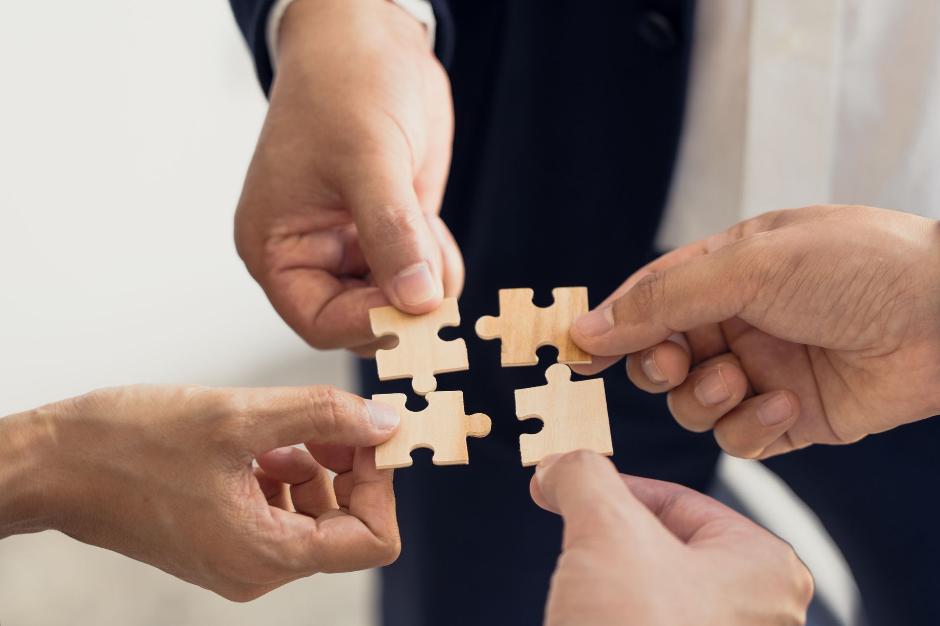Hands holding wooden puzzle pieces