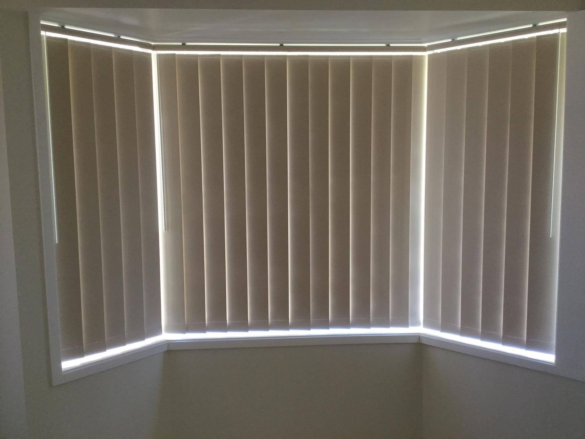 A Bay Window With Vertical Blinds on It — Design 2000 Blinds & Awnings In San Remo, NSW