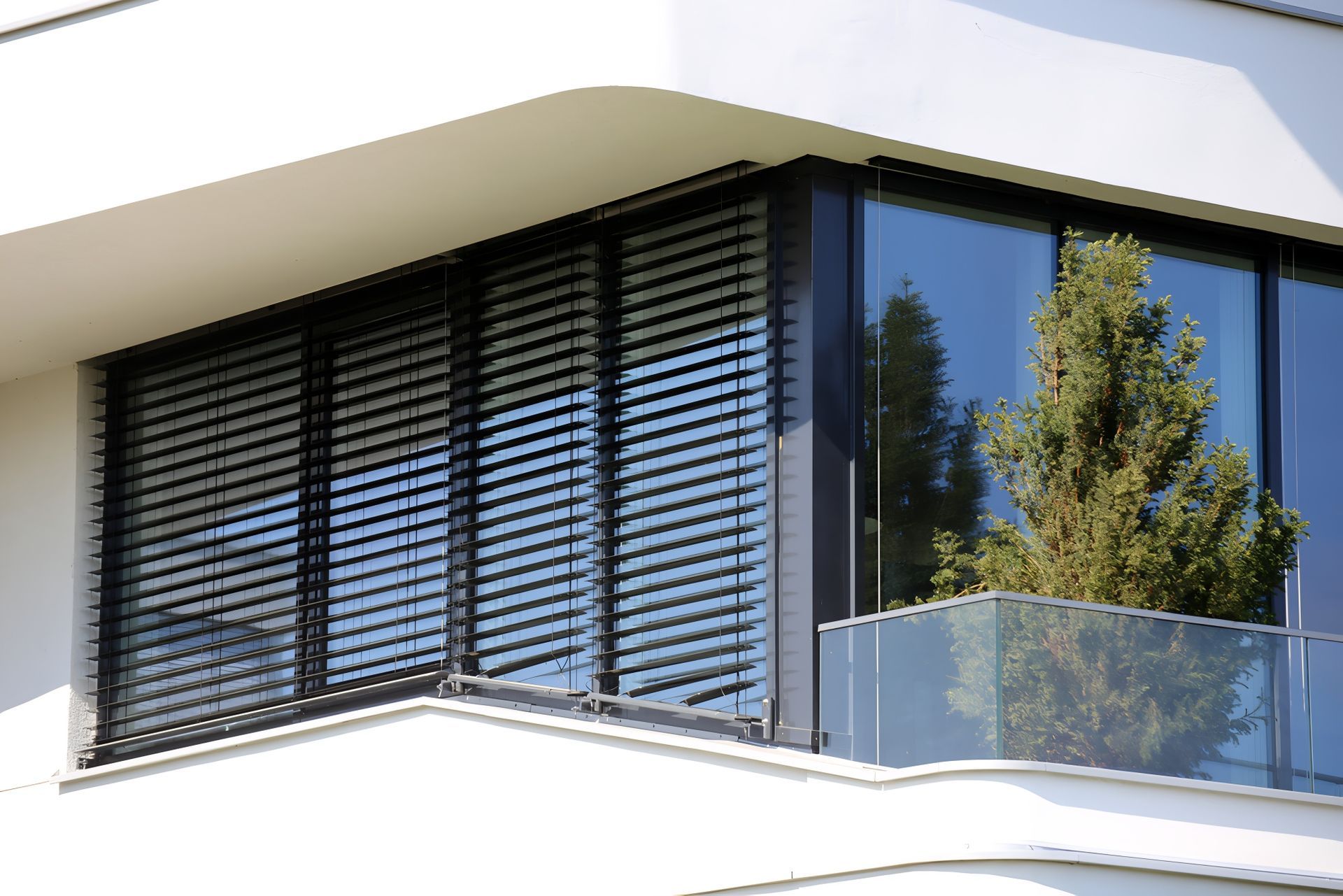A large window with blinds on it is on the side of a building. — Design 2000 Blinds & Awnings In San Remo, NSW