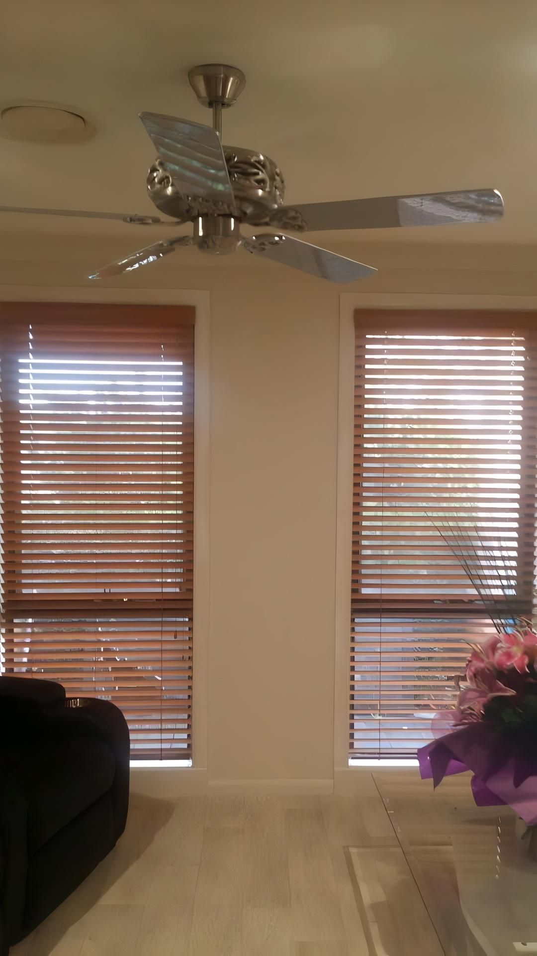 A Living Room With a Ceiling Fan and Blinds on the Windows — Design 2000 Blinds & Awnings In San Remo, NSW