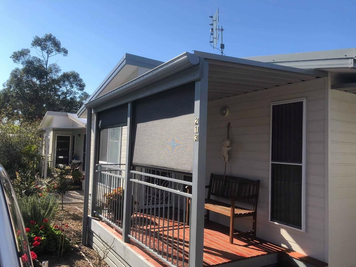 A White House With a Porch and a Bench on It — Design 2000 Blinds & Awnings In San Remo, NSW