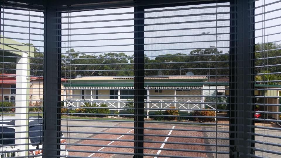 A View of a House Through a Window With Blinds — Design 2000 Blinds & Awnings In San Remo, NSW