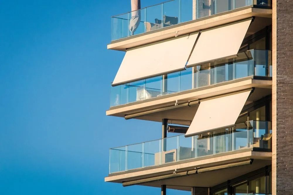 A Building With a Lot of Balconies and Awnings on Them — Design 2000 Blinds & Awnings In San Remo, NSW
