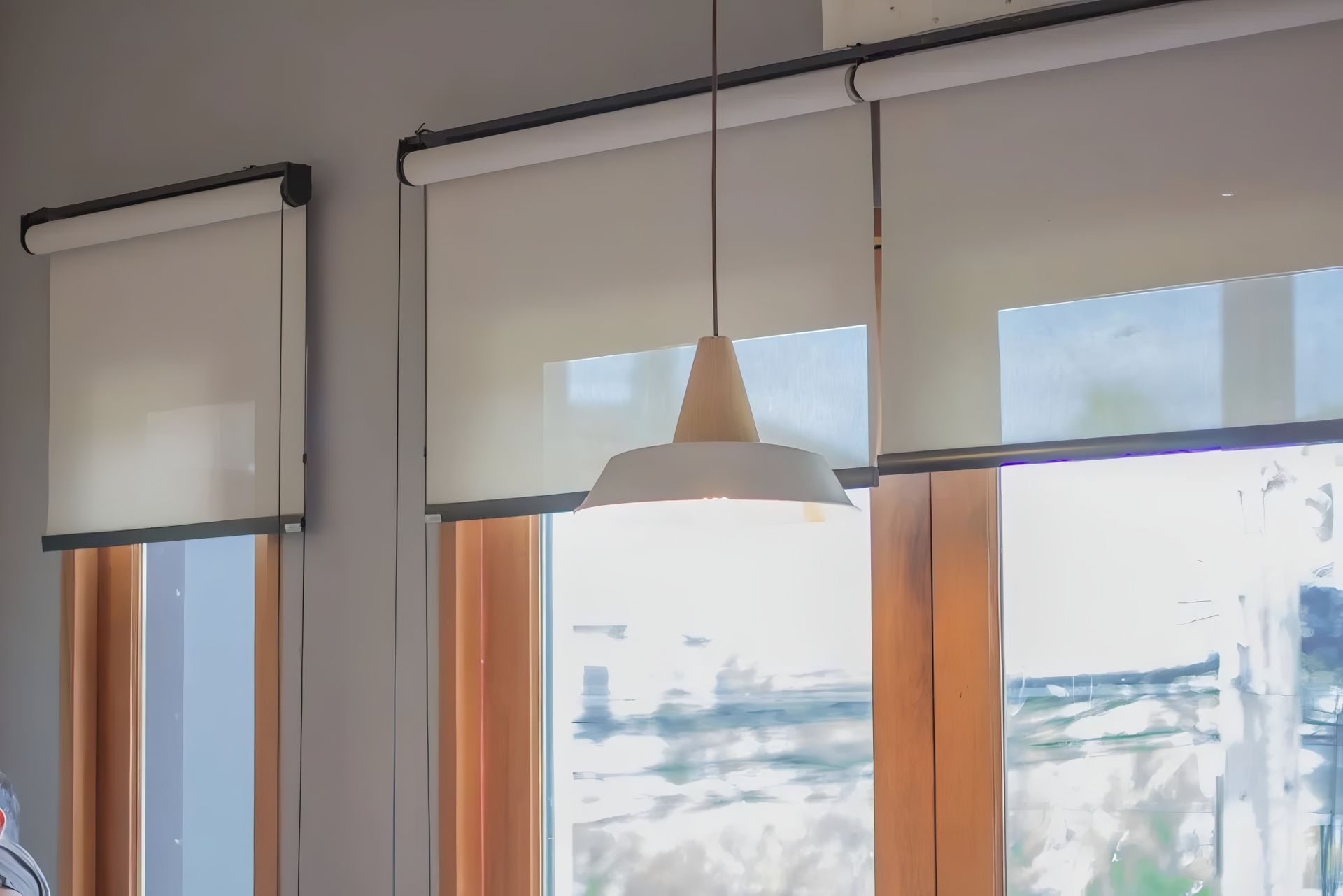 A Room With a Lot of Windows and Blinds and a Lamp Hanging From the Ceiling — Design 2000 Blinds & Awnings In San Remo, NSW