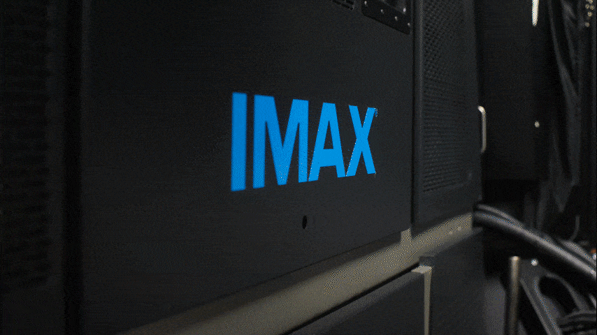 Close-up of a black IMAX projector or theater equipment with blue IMAX logo