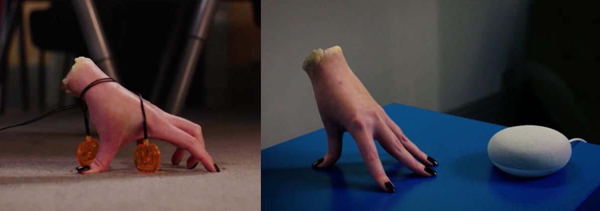 A woman 's hand is sitting on a blue table next to a white object.