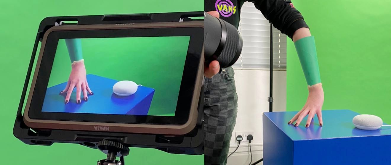 A person is holding a tablet in front of a green screen.
