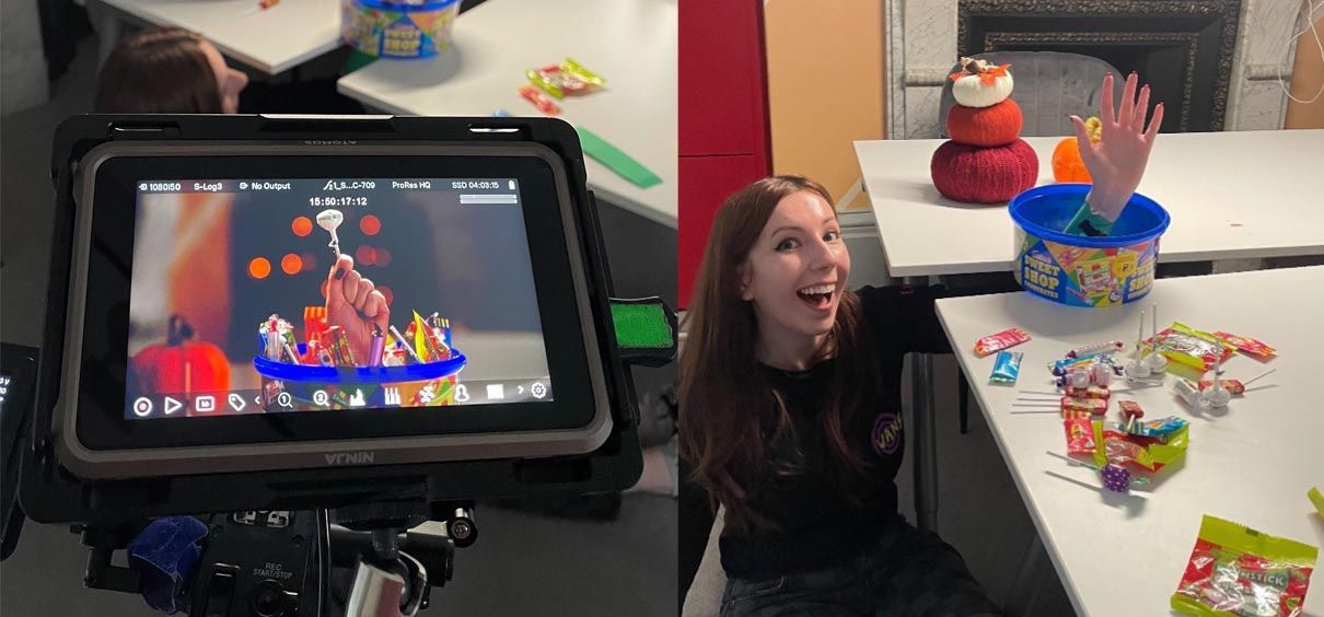 A girl is sitting at a table with a tablet and a camera.