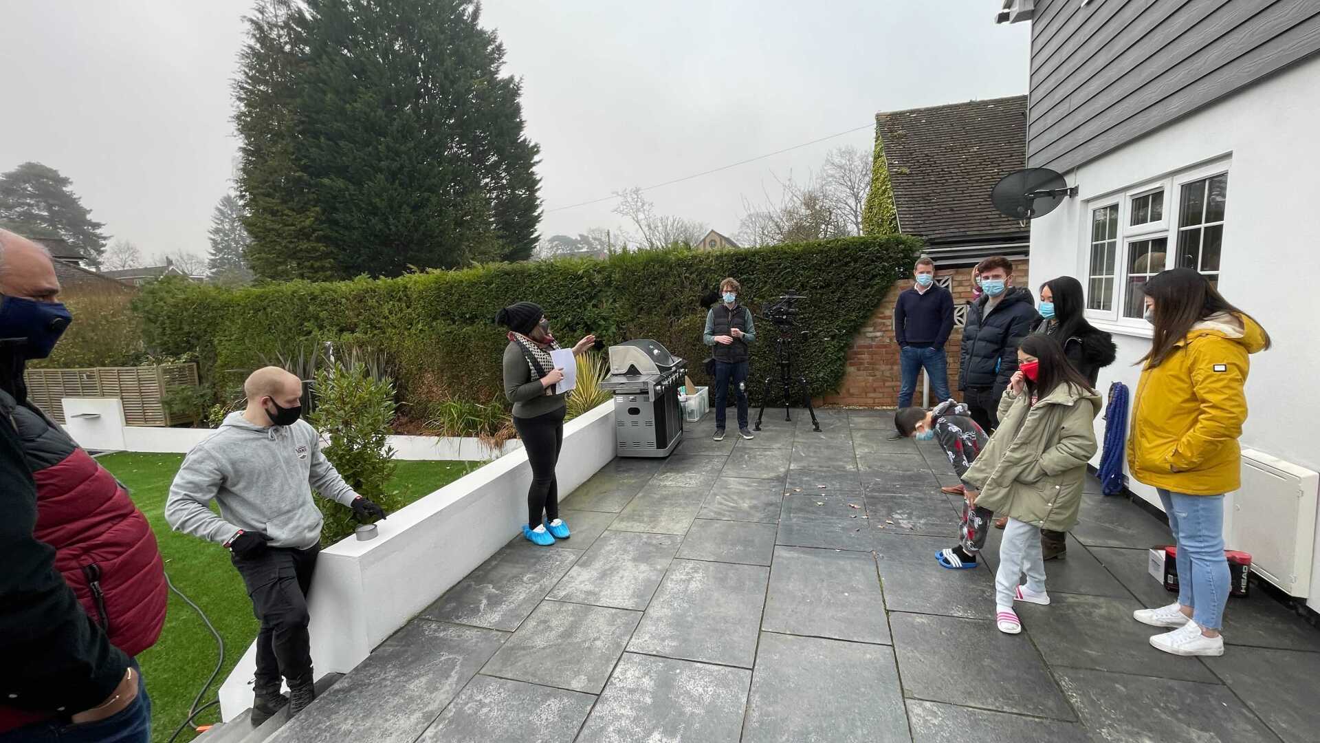A group of people are standing outside of a house.