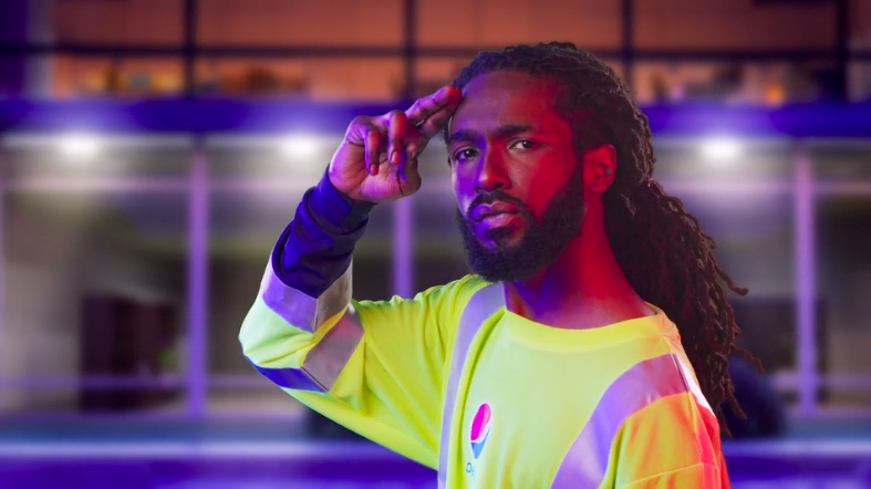 A man with long hair and a beard is wearing a neon yellow shirt.