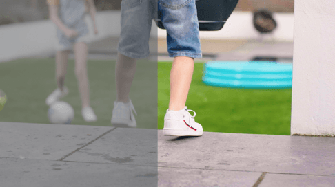 A person is walking on a sidewalk next to a pool.
