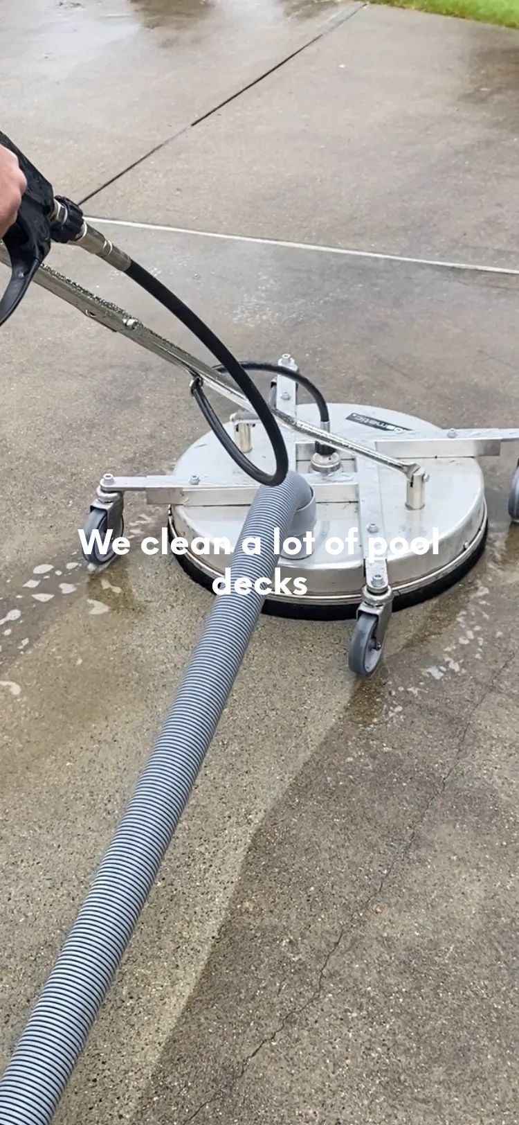 Pressure washer cleaning a concrete driveway with visible dirt removal