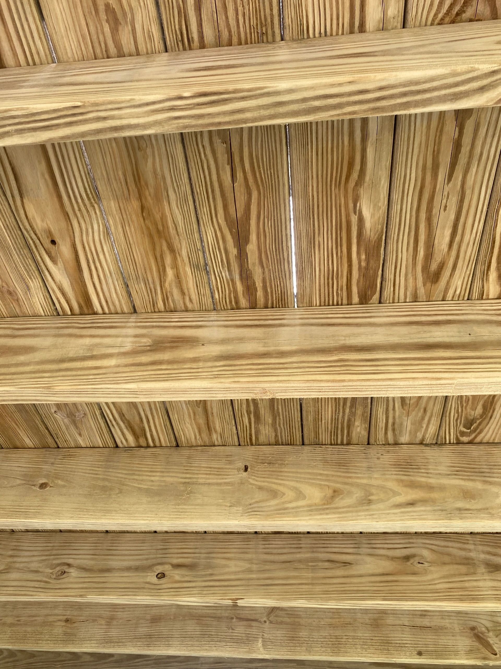 Close-up of a woven straw or bamboo ceiling with horizontal support beams
