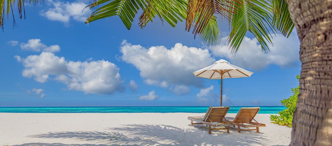 A sandy beach with two chairs and an umbrella representing the calm and peace that can be found after a couples retreat in Orlando, FL. Attend our intimacy workshop and see for yourself. Available in Florida, Georgia, North Carolina, and beyond.