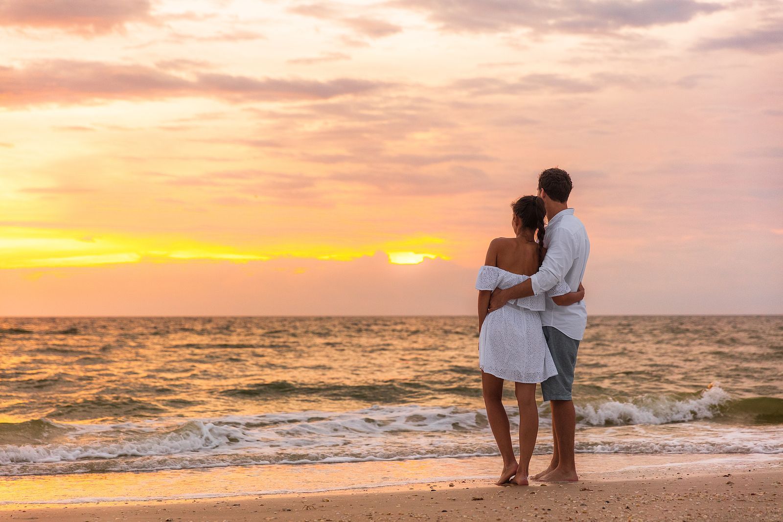 A couple embraces on the beach, their relationship renewed and strengthened due to a Couples Retreat in Orlando, FL. Hold Me Tight® workshops in Florida, Georgia, South Carolina, and beyond can help you build on couples therapy to improve your relationship.