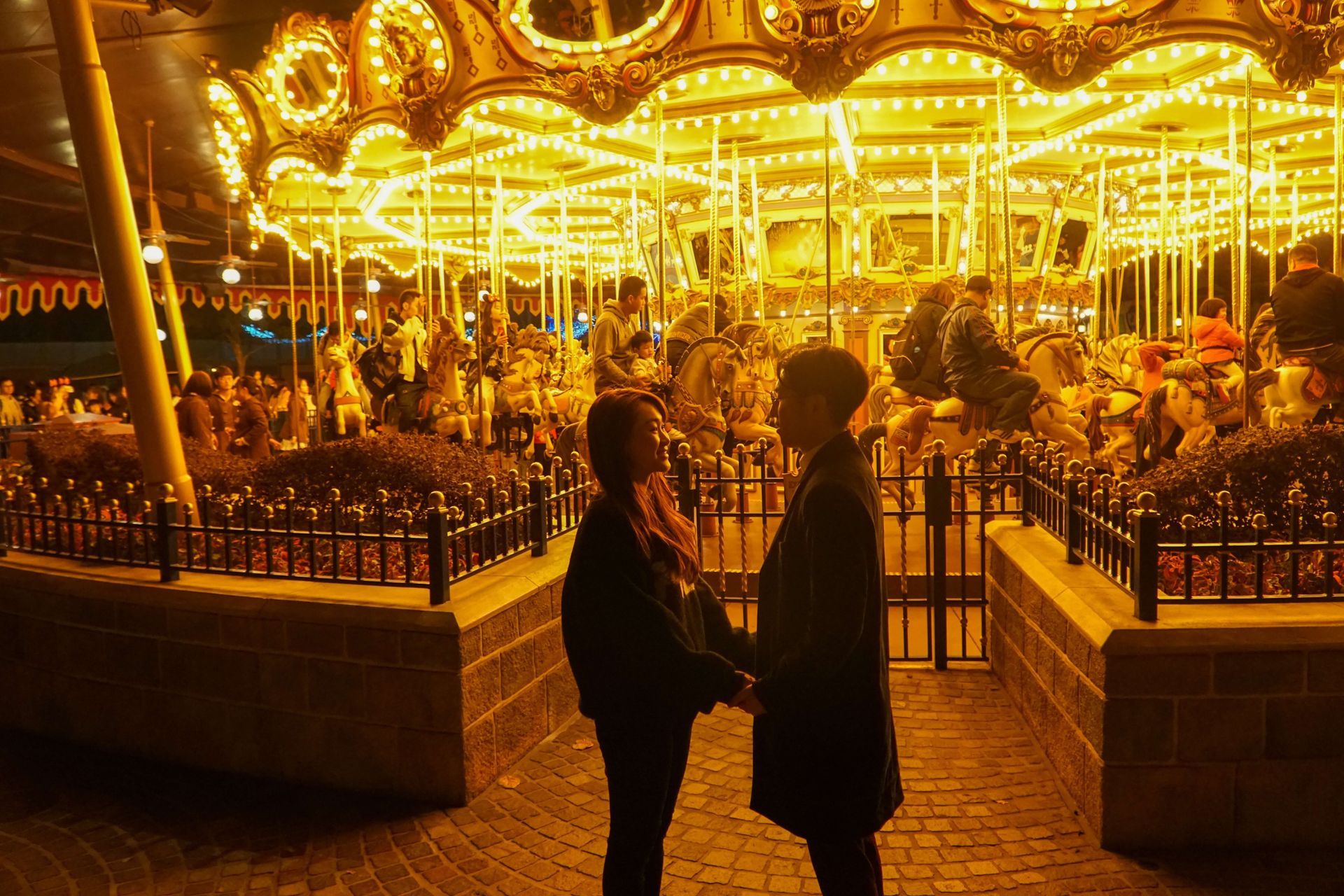A couple stands in front of a carousel at night after rekindling their relationship in a Couples Retreat in Orlando, FL. Couples throughout the United States are encouraged to come to our Couples Retreats in Florida.