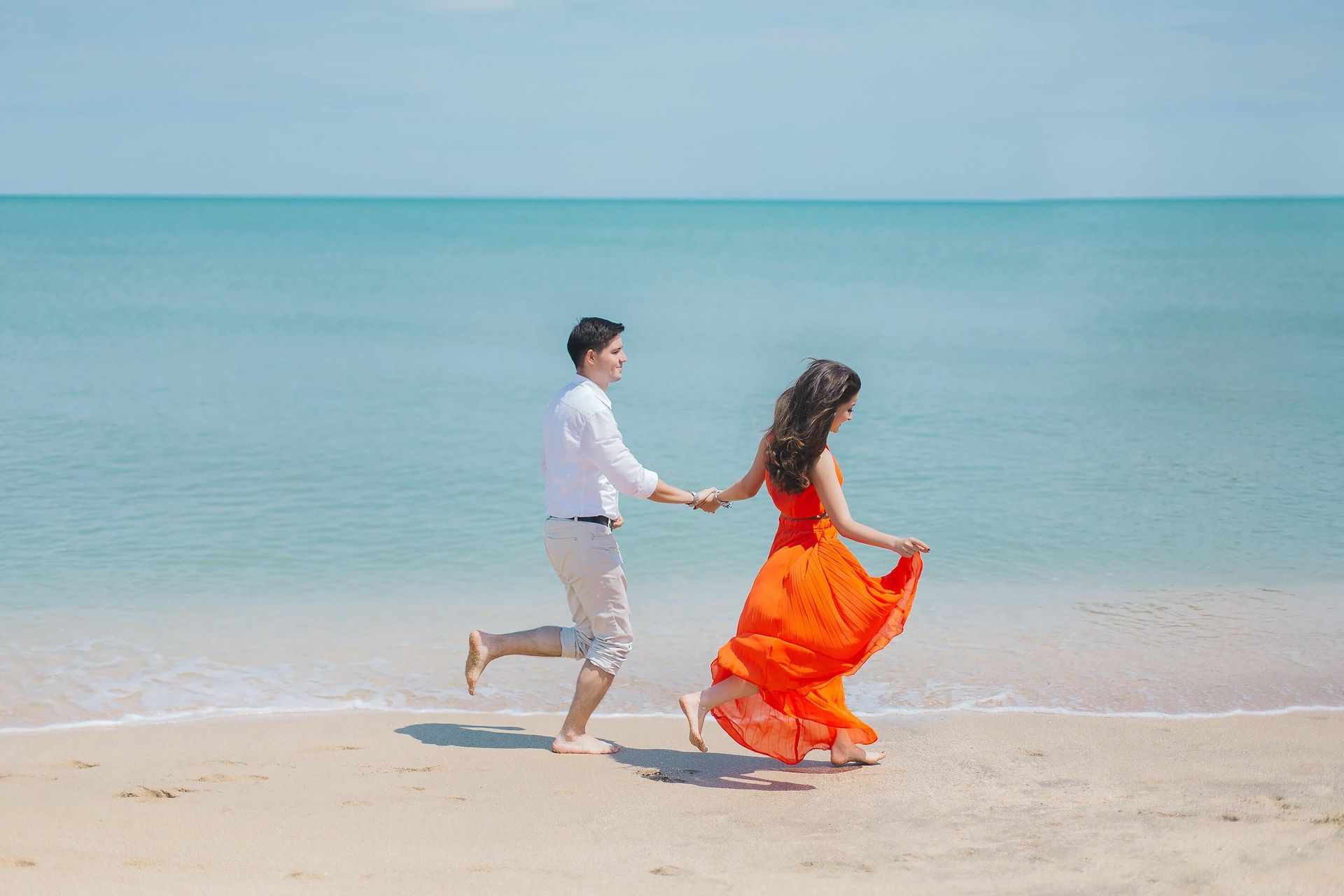 A couple walks on the beach together, reconnected after a Hold Me Tight® Couples Retreat in Orlando, FL. Couples Retreats are offered to couples in Florida and throughout the United States.