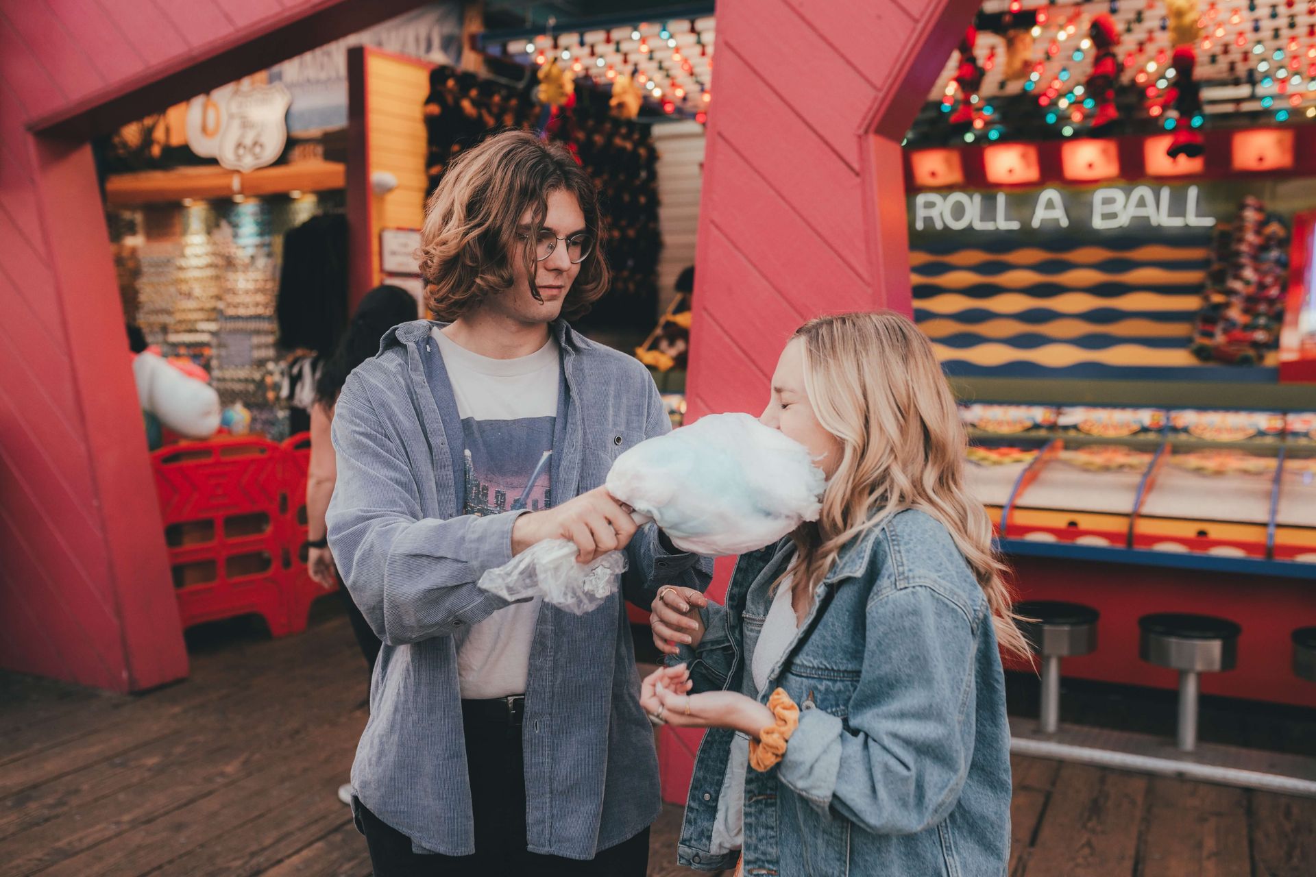 A couple eats cotton candy at a carnival representing the joy that can be found in your relationship with the help of Couples Retreats in Orlando, FL. Our Couples Retreats are available to couples anywhere in the United States.