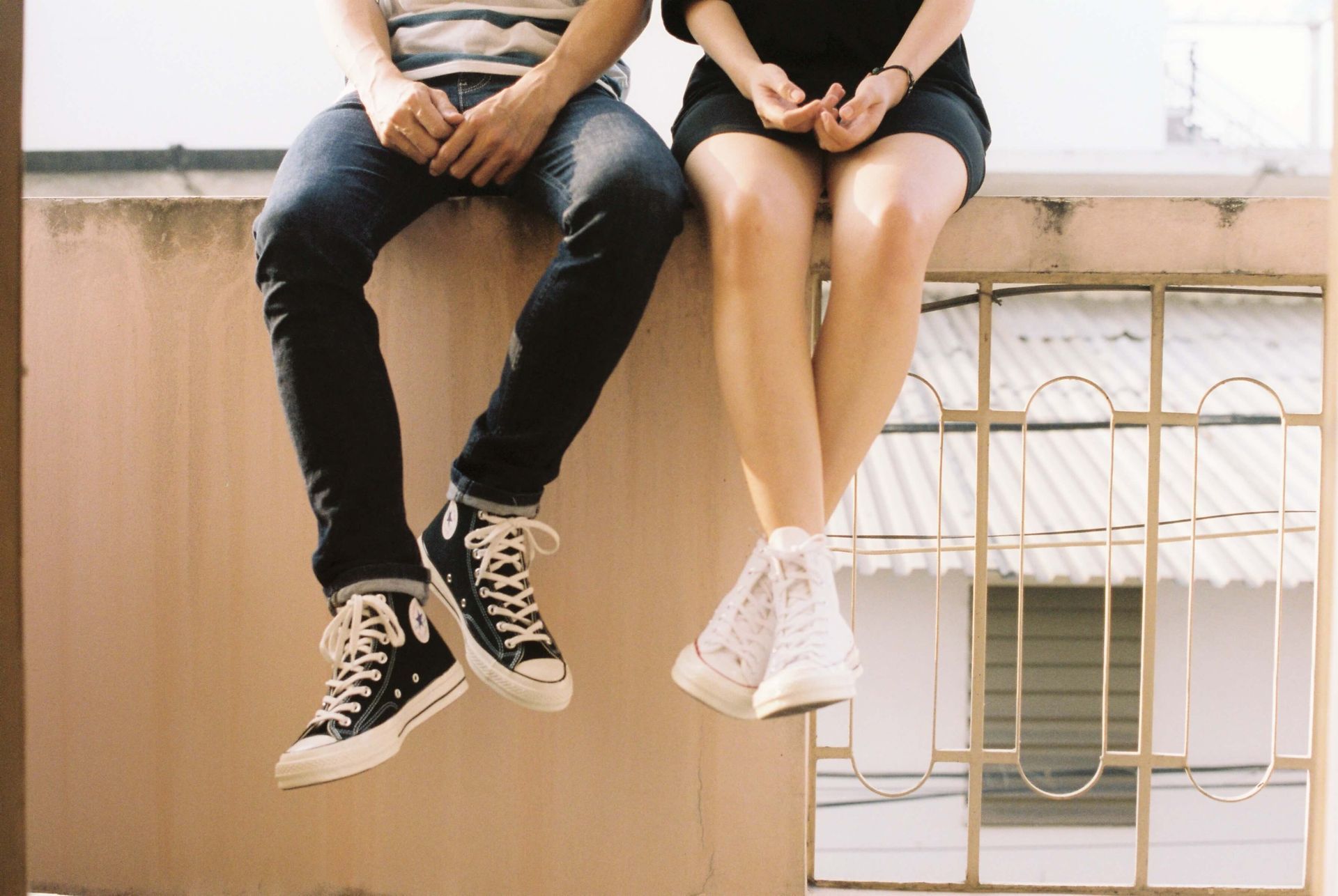 A man and a woman sit next to each other atop a wall struggling to connect representing a couple who could benefit from a Hold Me Tight® Couples Retreat in Orlando, FL. Couples Retreats are available to couples in Florida and throughout the United States.