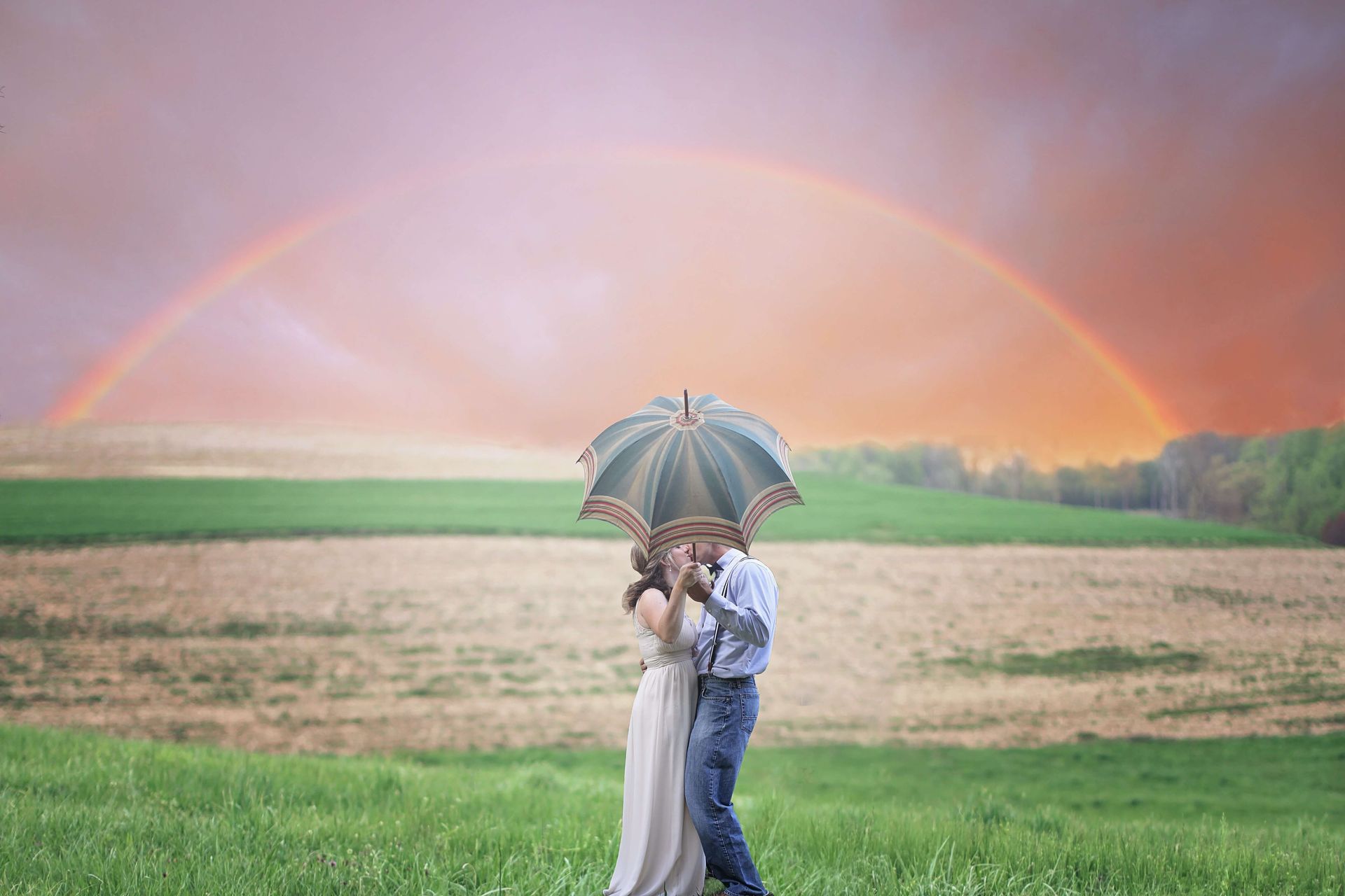 A couple kiss under an umbrella as a rainbow frames the sky. Reconnect and reignite the fires of love in a Couples Retreat in Orlando, FL. Our Couples Retreats are open to any couples in the United States and beyond.
