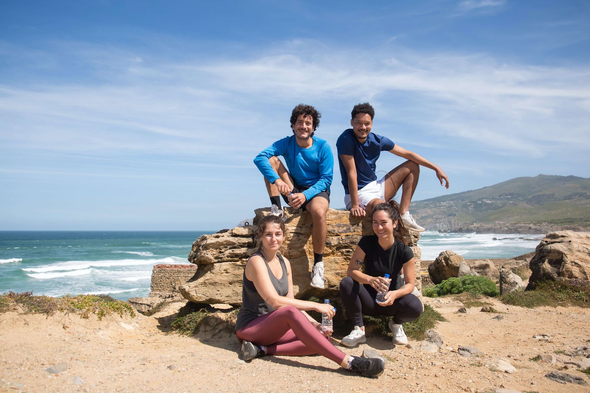 Two couples sit on a large rock overlooking the water representing a group that successfully completed a Couples Retreat in Florida together. Couples Retreats are available to couples in Florida, Georgia, North Carolina, and Beyond.