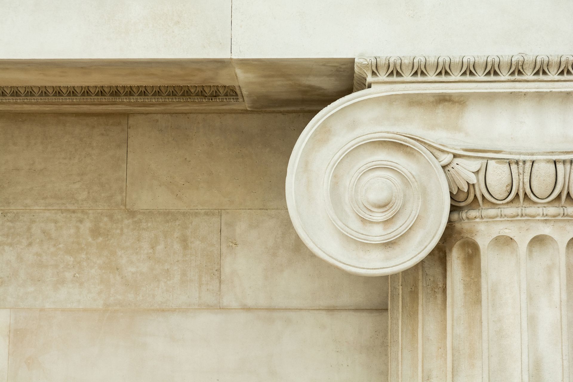 A close up of a pillar with a capital on a building.