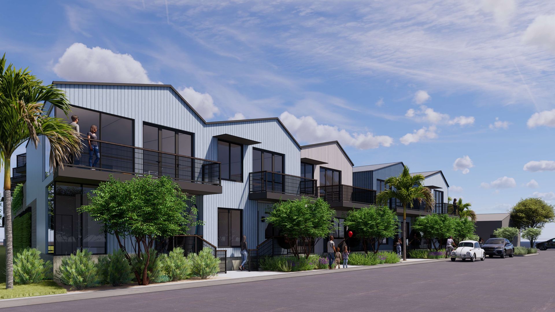 Row of modern townhouses with balconies, blue siding, and green landscaping.