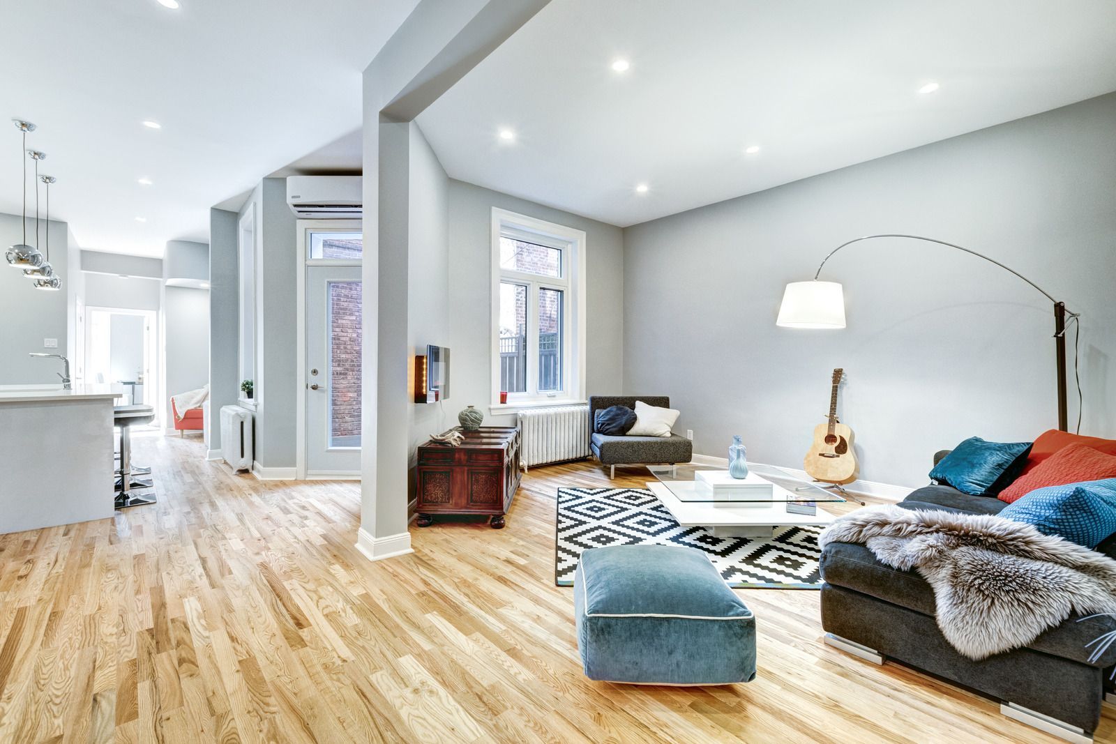 Bright living room with wood floors, light gray walls, and modern furniture.