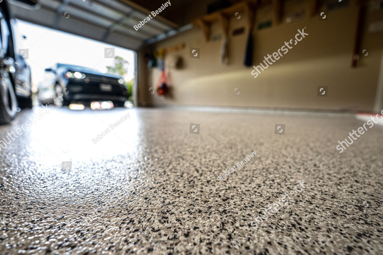 A car is parked in a garage with a concrete floor.