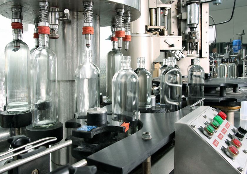 Bottiglie di vetro su un nastro trasportatore industriale per l’imbottigliamento