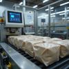 Barrette snack confezionate su un nastro trasportatore in fabbrica, accanto a una confezionatrice